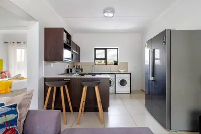 a kitchen with two bar stools and a kitchen with a sink at The View in Fourways