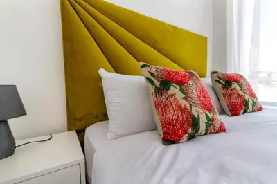 a bed with two pillows and a yellow headboard at The View in Fourways