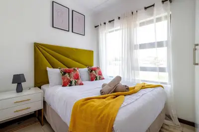 a bedroom with two beds with a teddy bear on a blanket at The View in Fourways