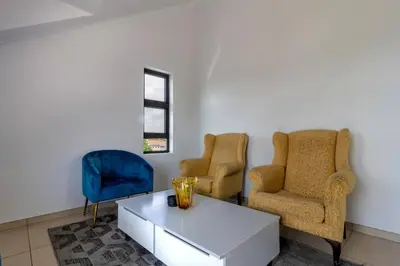 a living room with two chairs and a table at The View in Fourways