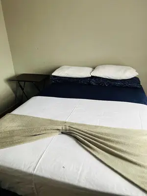 a bed with white sheets and two pillows on it at Kasi Retreat in Northam