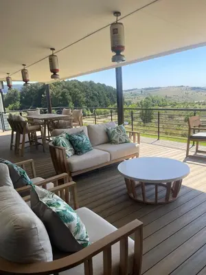 a living room with a couch and tables on a deck at Gratia et Pax in Dullstroom