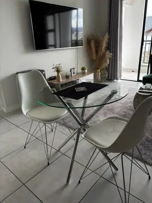 a dining room with a glass table and two chairs at The Dream Escape At The Blyde - One Bedroom Apartment in Pretoria