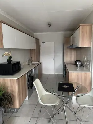 a kitchen with a table and chairs in a kitchen at The Dream Escape At The Blyde - One Bedroom Apartment in Pretoria