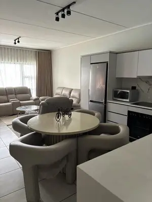 a kitchen and living room with a table and chairs at The Dream Escape At The Blyde - Lagoon Facing 3 Bedroom Apartment in Pretoria