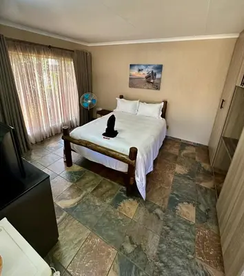 a bedroom with a bed with a cat sitting on it at Sky blue in Polokwane