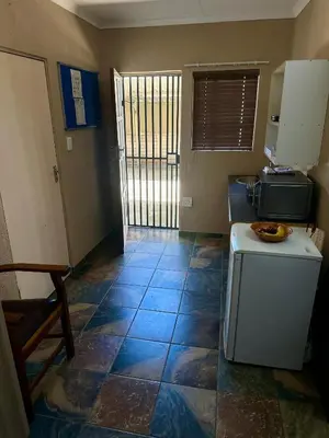 a kitchen with a small refrigerator and a table at Sky blue in Polokwane