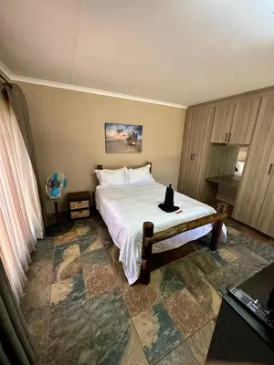 a bedroom with a bed with a cat sitting on it at Sky blue in Polokwane