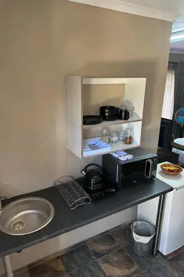 a kitchen counter with a microwave and a sink at Sky blue in Polokwane