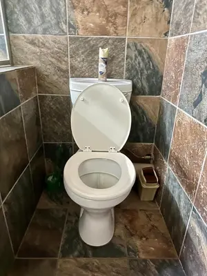 a bathroom with a white toilet in a tiled room at Sky blue in Polokwane