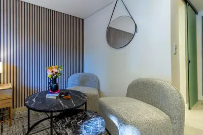 two chairs and a table with a vase of flowers at #AlimamaSpaces Rob's Menlyn Maine in Pretoria