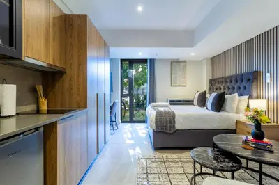 a hotel room with a bed and a table at #AlimamaSpaces Rob's Menlyn Maine in Pretoria