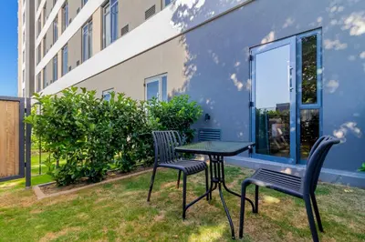 two chairs and a table in a yard next to a building at #AlimamaSpaces Manson's Menlyn Maine in Pretoria