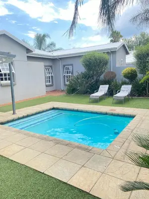 a swimming pool in front of a house at Andisa Cozy Stay in Kempton Park