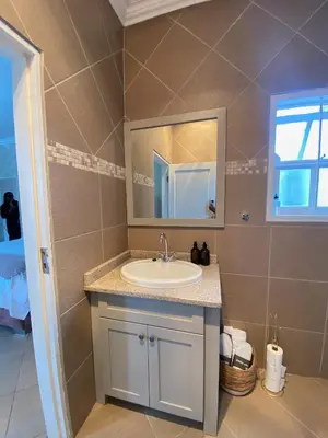 a bathroom with a sink and a mirror at Andisa Cozy Stay in Kempton Park