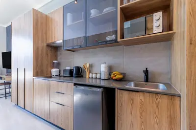a kitchen with wooden cabinets and a stainless steel dishwasher at #AlimamaSpaces Chelsea's Menlyn Maine in Pretoria