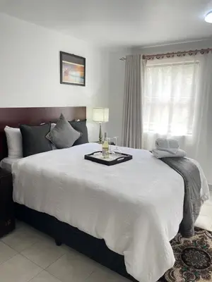 a bedroom with a large bed with a table on it at Green View Guest House Middelburg in Middelburg