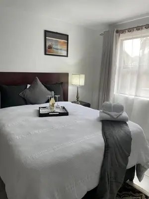 a bedroom with a large white bed and a window at Green View Guest House Middelburg in Middelburg