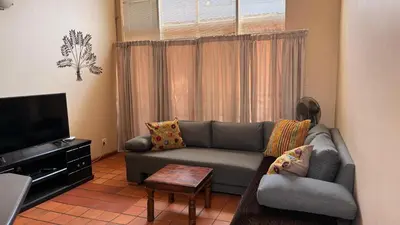a living room with a couch and a television at Contractor Stay Units in Middelburg