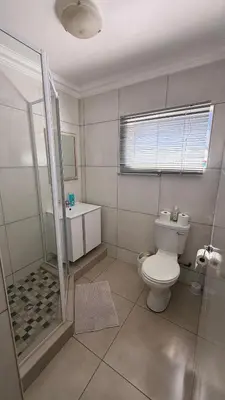 a bathroom with a toilet and a shower and a sink at Contractor Stay Units in Middelburg