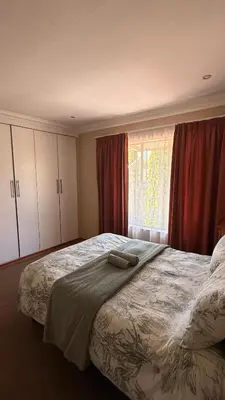 a bedroom with a large bed and a window at Contractor Stay Units in Middelburg