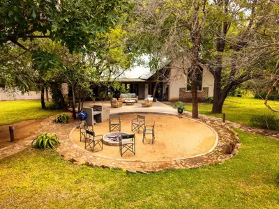 a patio with chairs and tables in a yard at Ubungane Lodge in Makalali Game Reserve