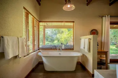 a large bathroom with a tub and a window at Ubungane Lodge in Makalali Game Reserve
