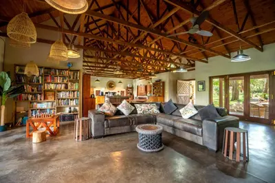 a living room with a couch and a book shelf at Ubungane Lodge in Makalali Game Reserve