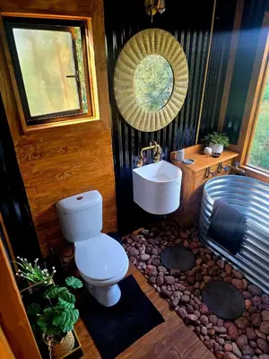 a bathroom with a toilet and a sink at Tin Town Glamping in Haenertsburg