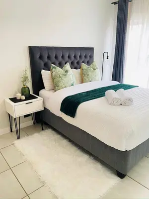 a bedroom with a large bed with towels on it at TwoHorse Properties in Pretoria
