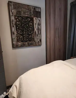 a bedroom with a bed and a painting on the wall at Ibunami in Midrand
