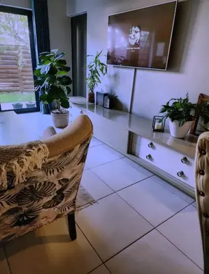 a living room with a tv and a couch at Ibunami in Midrand