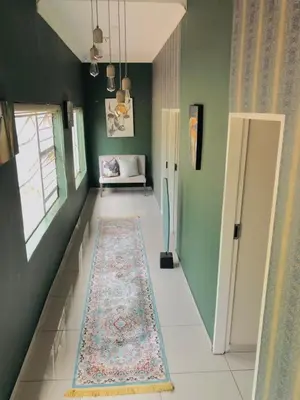 a hallway with green walls and a rug on the floor at Royal Bliss Lodge and Spa in Midrand