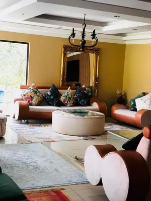 a living room with a couch and a mirror at Royal Bliss Lodge and Spa in Midrand