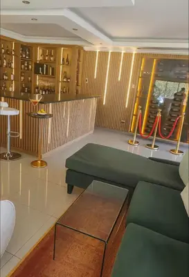 a living room with a green couch and a table at Royal Bliss Lodge and Spa in Midrand