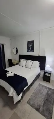a bedroom with a large white bed in a room at Golden Stay Guest House in Nelspruit