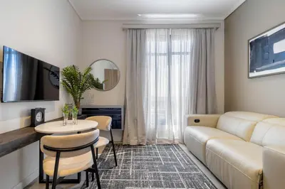 a living room with a couch and a table at #AlimamaSpaces The Nook Menlyn Maine Studio in Pretoria
