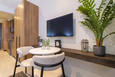 a room with a table and two chairs and a tv at #AlimamaSpaces The Nook Menlyn Maine Studio in Pretoria