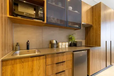 a kitchen with a sink and a microwave at #AlimamaSpaces The Nook Menlyn Maine Studio in Pretoria