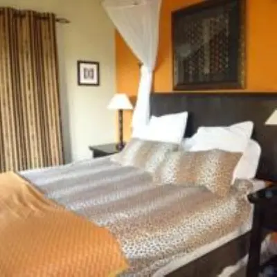 a bedroom with a large bed with white pillows at Hazyview Country Estate in Swartfontein