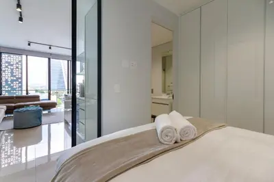 a bedroom with a bed with towels on it at #AlimamaSpaces The Phum's Ellipse in Midrand