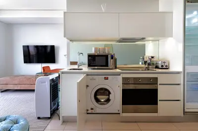 a kitchen with a washing machine and a microwave at #AlimamaSpaces The Phum's Ellipse in Midrand