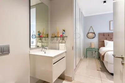 a white bathroom with a sink and a bed at #AlimamaSpaces The Phum's Ellipse in Midrand