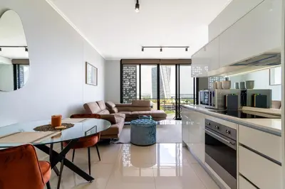 a kitchen with a table and a living room at #AlimamaSpaces The Phum's Ellipse in Midrand