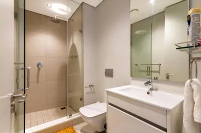 a bathroom with a shower and a sink and a toilet at #AlimamaSpaces The Phum's Ellipse in Midrand
