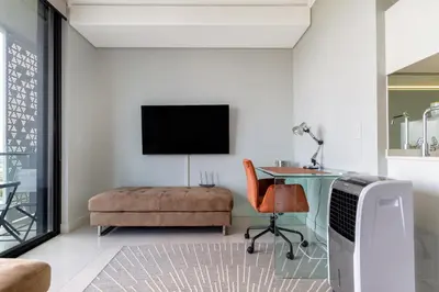 a living room with a desk and a chair and a tv at #AlimamaSpaces The Phum's Ellipse in Midrand