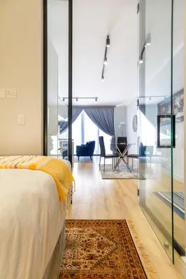 a bedroom with a bed and a living room at #AlimamaSpaces The Ace's Ellipse in Midrand