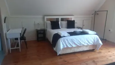 a bedroom with a large bed with a desk and a desk at Bush Babies Cottage in Marloth Park