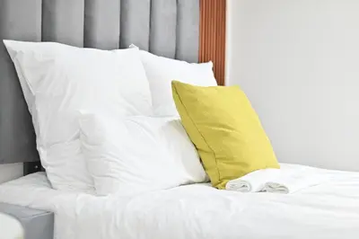 a bed with white pillows and a yellow pillow at Sunset Lodge - Gundani in Thengwe
