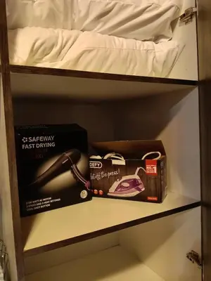 a box on a shelf next to a bed at Cozy Corner Cottage near wilgers hospital & Menlyn in Pretoria